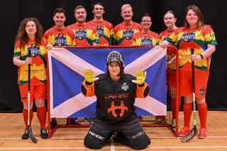 Perth Parrots Floorball squad in their team kit holding a Scottish St Andrews flag