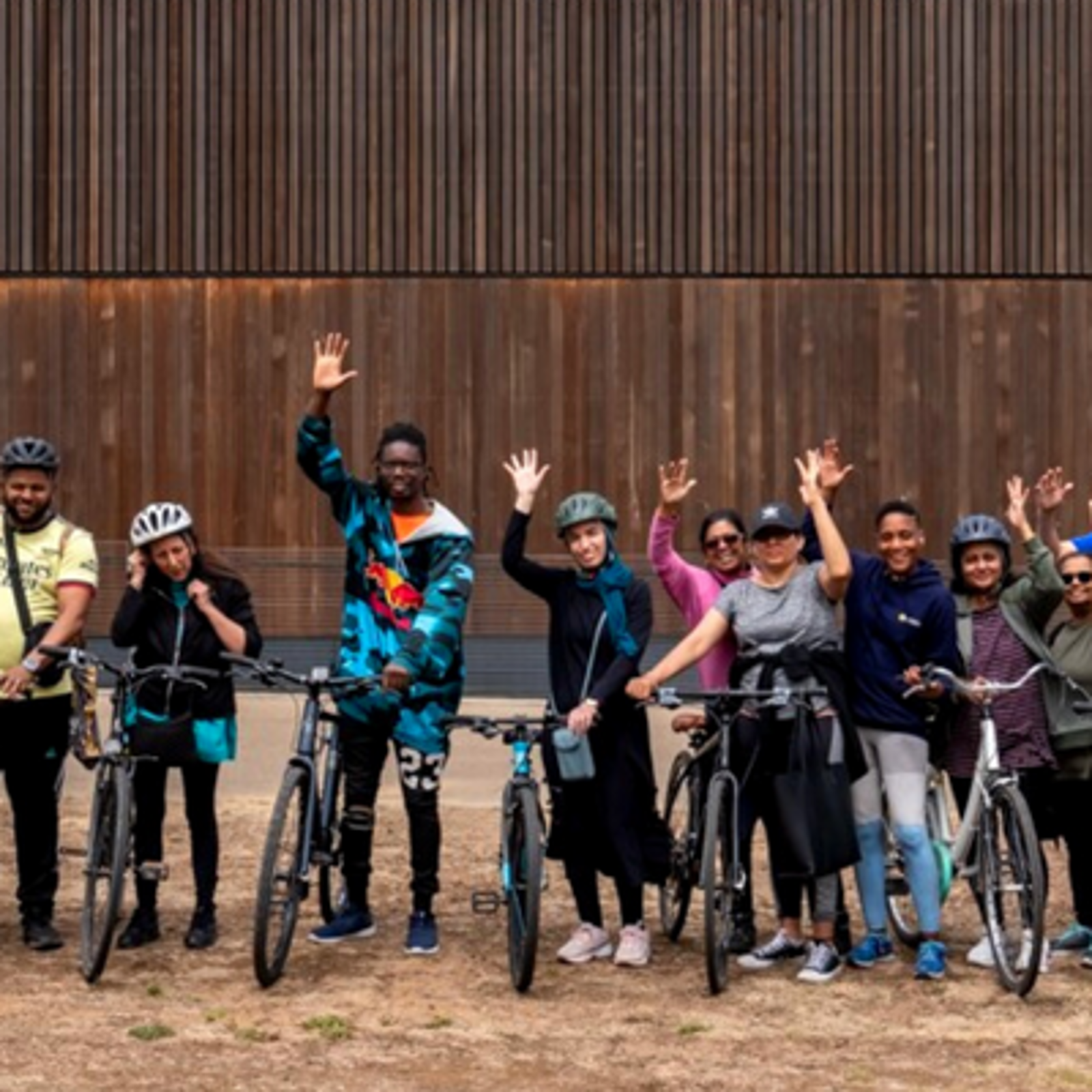 Group of cyclists waving to camera