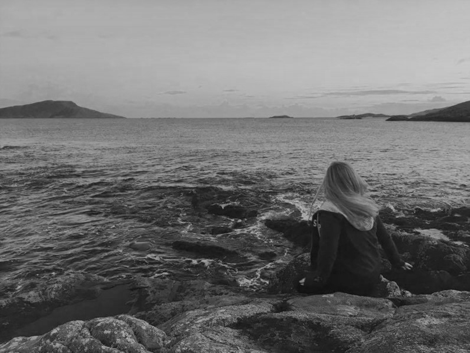 Young girl pictured with her back to camera on the beach at the Isle of Barra, Scotland