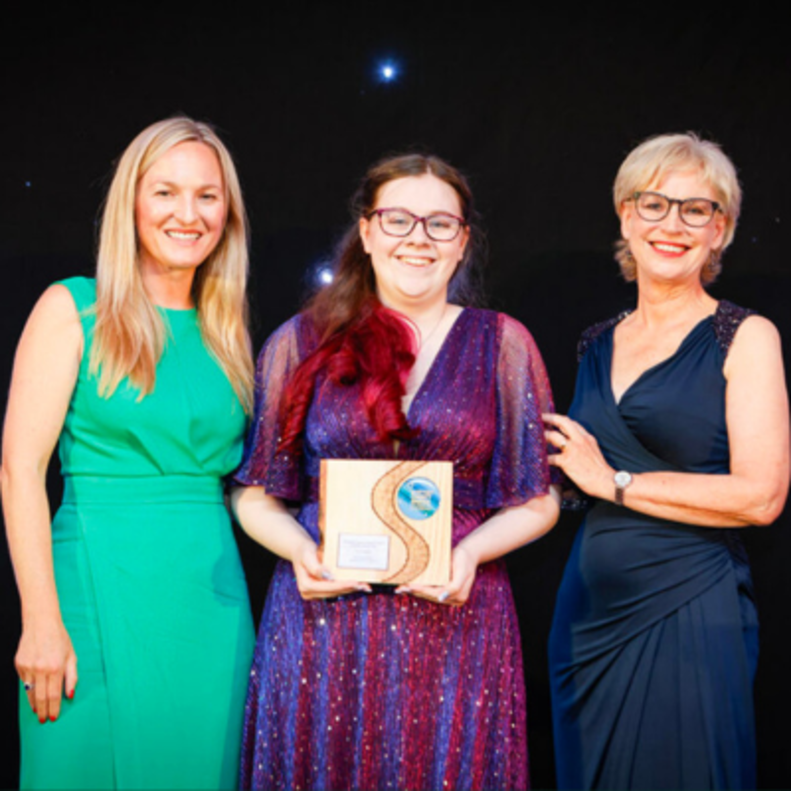 Kaydi with awards hosts, holding her Scottish Charity of the Year award