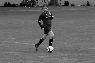 Olivia playing kicking a football on the pitch
