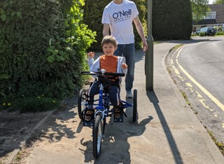 Little boy in a blue tshirt on an adapted trike