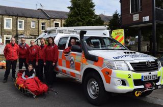Rossendale And Pendle Mountain Rescue Team standing with emergency vehicle