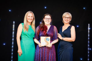 Kaydi with awards hosts, holding her Scottish Charity of the Year award