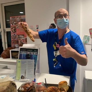 A Doctor holding up breakfast donated by Hospitality For Heroes 