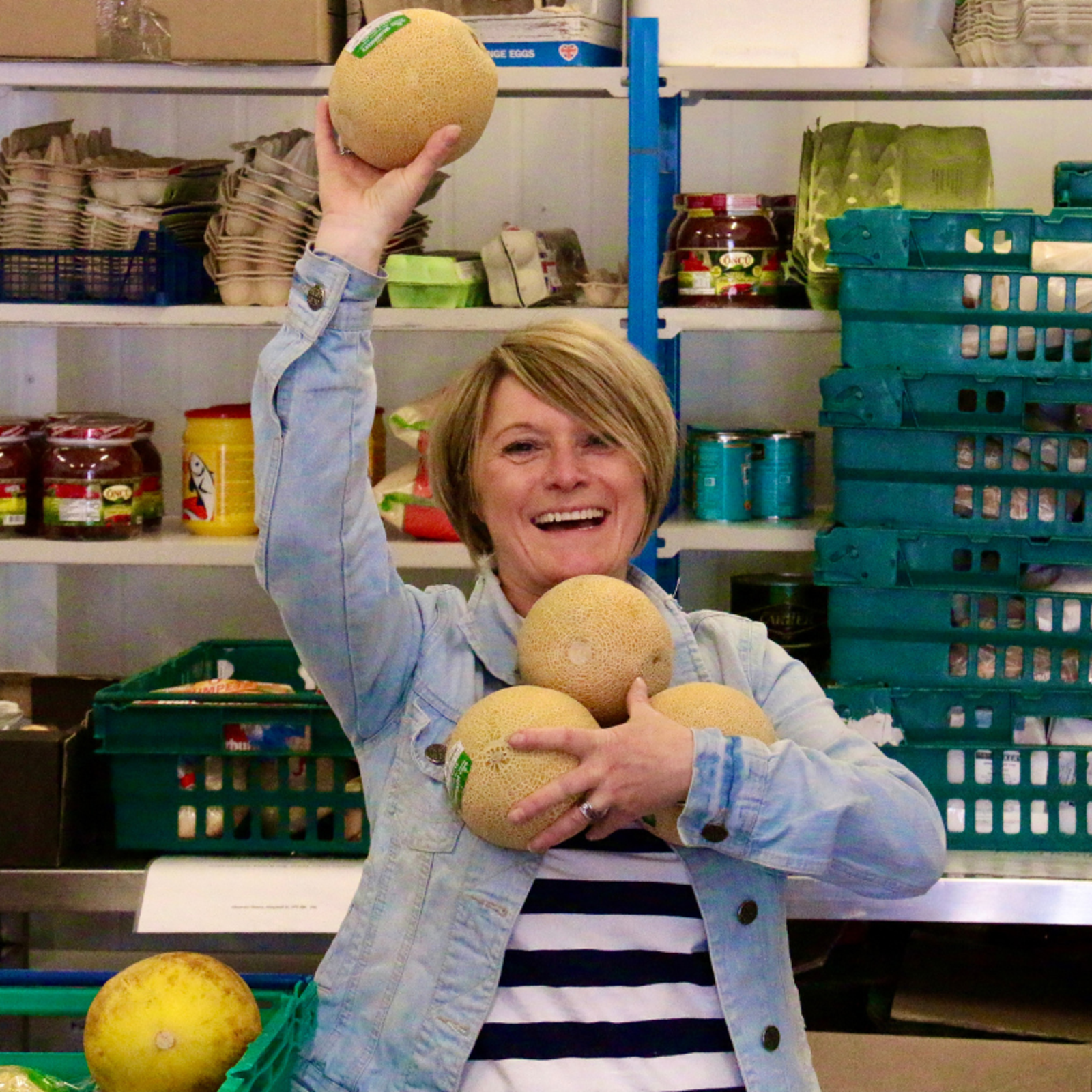 Shrewsbury Food Hub volunteer holding up melons