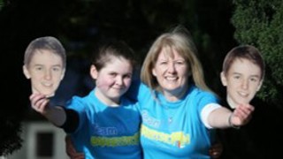 Ben's sister, Ava, and mum, Orla, holding photos of Ben.