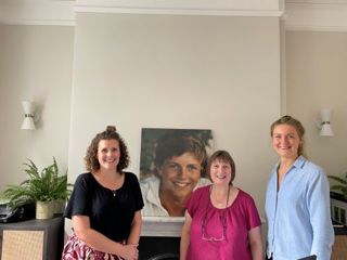 Amy, Head of Development, alongside receptionist Maureen Reeves and Sarah James, ACT Manager. Behind you can see a picture of James, whose story is at the heart of James' Place.
